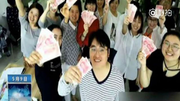 직원들이 상금을 들고 웃고 있는 사진