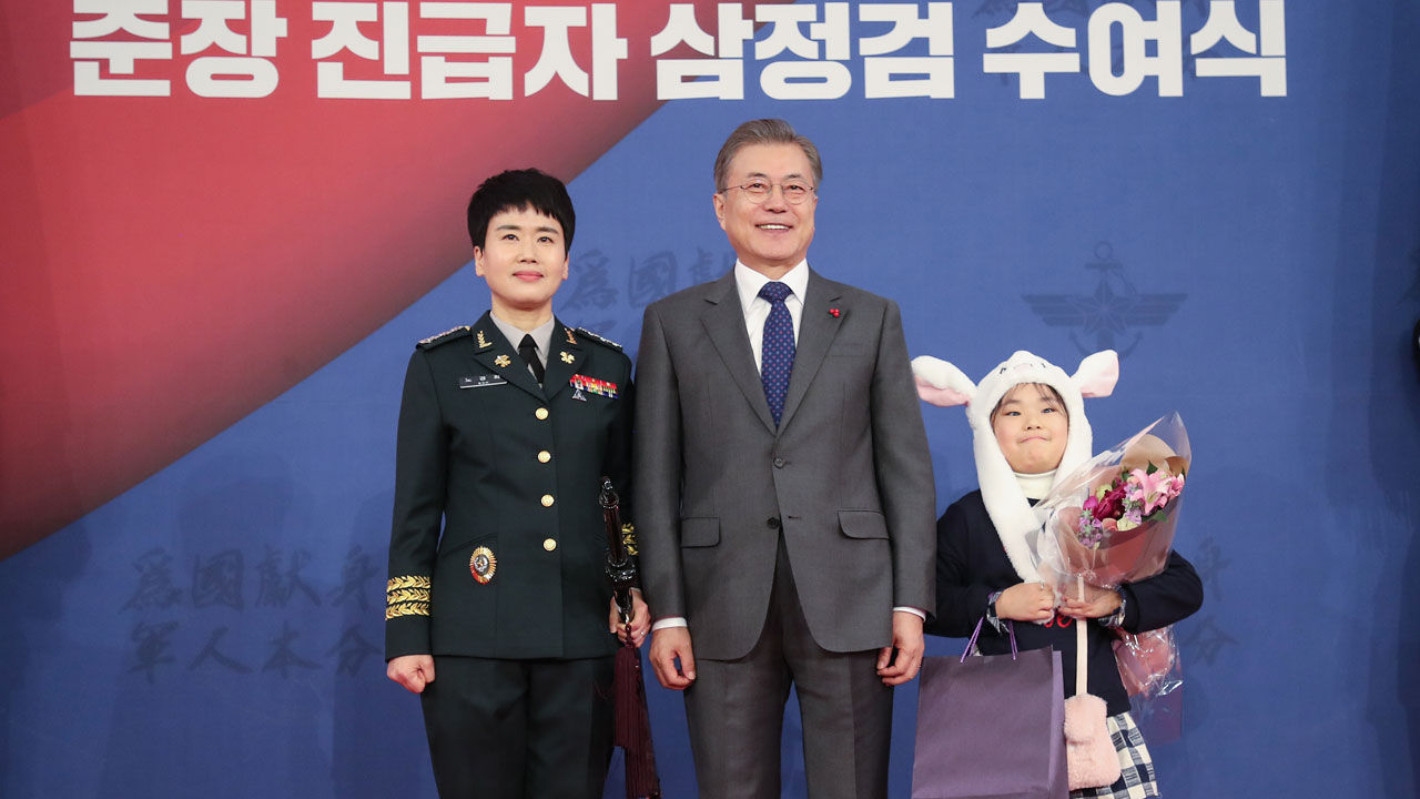 문재인 대통령이 8일 오후 청와대 춘추관에서 열린 지상작전사령부 창설 부대기 및 준장 진급자 삼정검 수여식에서 준장 진급예정자인 노경희 3사단 부사단장에게 삼정검을 수여하고 있다. 엄마를 따라온 딸 김시현 양이 토끼 모자를 쓰고 바라보고 있다.