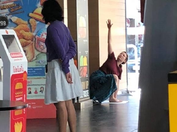 음식점 한가운데에서 요가 하는 관광객