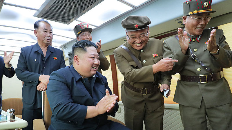 김정은 위원장이 지휘소 안에서 수행 간부들과 박수를 치며 즐거워 하고 있는 모습이다.