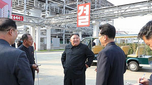 공장을 둘러보며 활짝 웃고 있는 검은 인민복 차림의 김정은 위원장 (사진=노동신문 홈페이지 캡처, 연합뉴스)