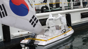 충남 태안군 소원면 의항리 해변에서 발견한 소형 보트를 감식 중인 해경 관계자들