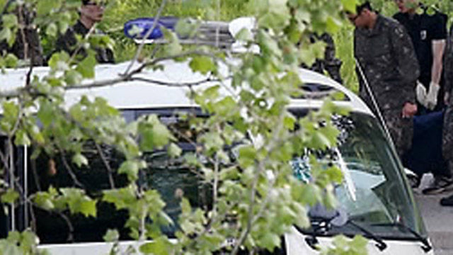 메인이미지  3 : 13일 오전 예비군 사격훈련중 총기 사망사고가 발생한 예비군 훈련장에서 군 관계자들이 총기를 난사하고 자살한 예비군의 시신을 들고 이동하고 있다. (서울=연합)