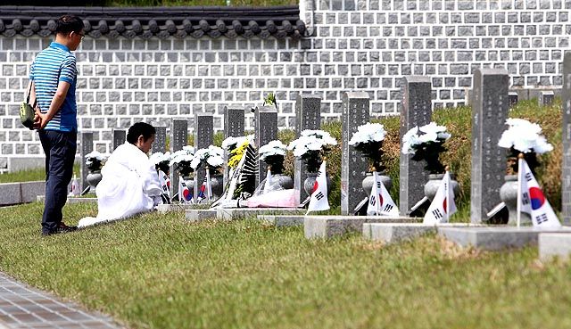 메인이미지  4 :  제 35주년 광주민주화운동 기념식을 하루 앞둔 17일 오전 광주 북구 운정동 국립 5&middot;18민주묘지를 찾은 유가족들이 묘지 앞에서 슬픔에 젖어 있다. 