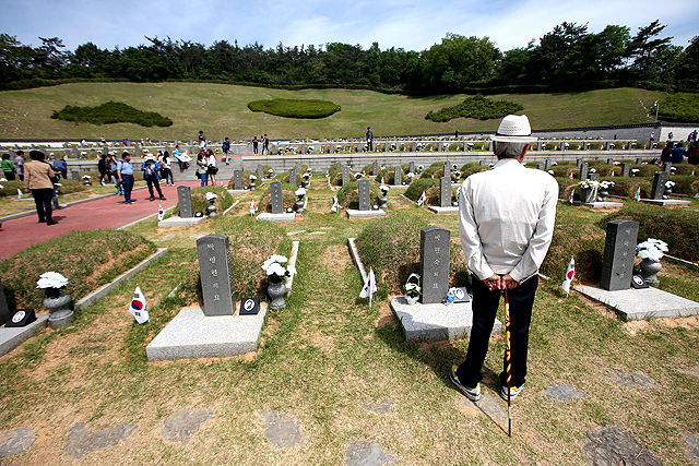 메인이미지  2 :  제 35주년 광주민주화운동 기념식을 하루 앞둔 17일 오전 광주 북구 운정동 국립 5&middot;18민주묘지를 찾은 한 신사가 묘역을 바라보고 있다.