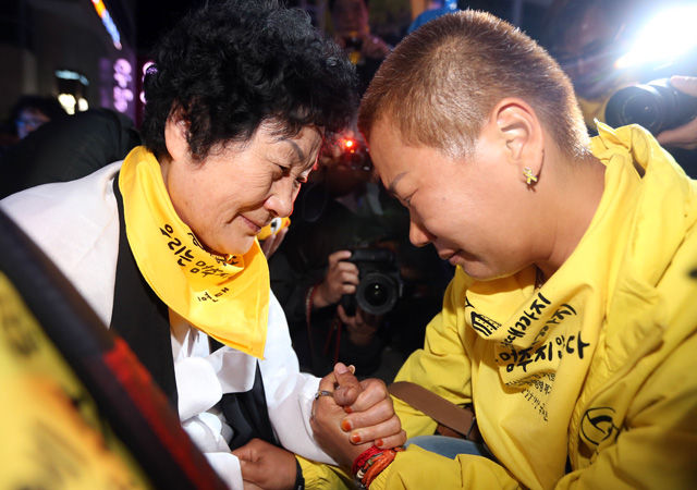 메인이미지  2 : 35주년 5&middot;18광주민주화운동 기념식을 하루 앞둔 17일 오후 광주 동구 금남로 거리에서 열린 전야제에서 5&middot;18 민주화운동 유족과 세월호 단원고 희생자 가족이 만나 손을 맞잡고 눈물을 흘리고 있다. (광주=연합뉴스)