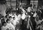 섬네일이미지  2:1948년 한 무녀가 양손에 돼지족발을 하나씩 들고 굿을 펼치고 있다. 동네 꼬마 녀석들과 부녀자들이 빽빽하게 모여 앉아 굿 구경을 하고 있다. 이 사진은 당시 국내에 있던 한 미군이 촬영한 것으로 김한근 부경근대사료연구소 소장이 미국의 한 수집가로부터 입수했다. << 부경근대사료연구소 제공 >> (부산=연합뉴스)