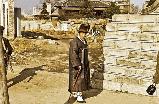 메인이미지  9 : 사진은 황폐화 된 시내를 배경으로 한복을 말끔히 차려입고 걷는 노신사의 모습. (듀이 맥린 박사 제공)