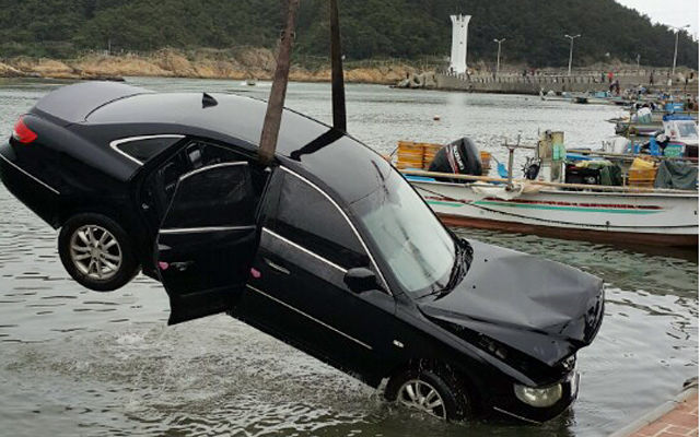 메인이미지  2 : 27일 오후 11시 50분께 부산시 기장군 기장읍의 한 복지관 앞 물양장에서 바다에 빠졌던 승용차가 28일 견인되고 있다. 차에 타고 있던 10대 5명은 모두 무사히 탈출했다. (울산=연합)