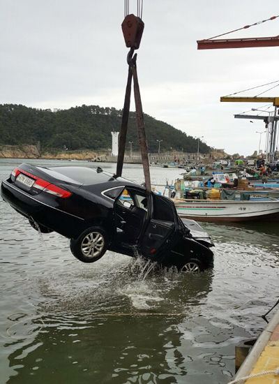 메인이미지  3 : 27일 오후 11시 50분께 부산시 기장군 기장읍의 한 복지관 앞 물양장에서 바다에 빠졌던 승용차가 28일 견인되고 있다. 차에 타고 있던 10대 5명은 모두 무사히 탈출했다. (울산=연합)