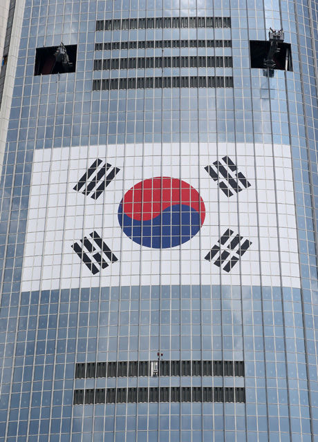 메인이미지  5 :  6일 오후 서울 잠실 롯데월드 타워에 초대형 태극기가 부착되어 있다. 롯데물산 측은 이날 "광복 70주년을 기념해 롯데월드타워에 가로 36m의 태극기를 설치했다"며 "높이는 약 304m로 국내 최고 높이에 부착된 태극기다"라고 설명했다. (서울=연합뉴스)