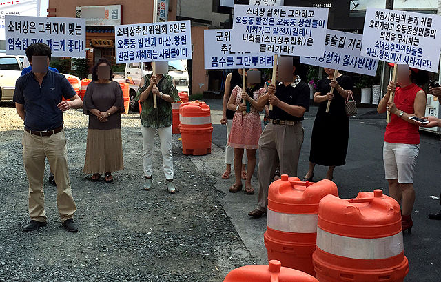 메인이미지  2 : 경남 창원시 마산합포구 오동동 유흥가 상인과 건물주 10여명이 지난 7일 일본군 위안부 추모비 건립추진위원회가 시민성금을 모아 만든 소녀상을 세울 예정인 곳에서 "전통술집거리에 위안부 소녀상 설치를 결사반대한다"며 피켓팅을 하고 있다. 