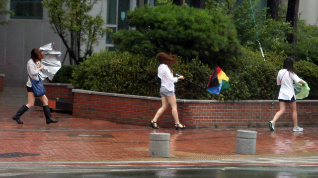 메인이미지  6 : 25일 제15호 태풍 '고니'가 북상중인 가운데 부산 해운대구 센텀시티에서 직장인들이 우산을 들고 힙겹게 출근하고 있다. 기상청은 이날 오전 9시를 기해 부산에 태풍경보를 발령했다. (부산=연합뉴스)