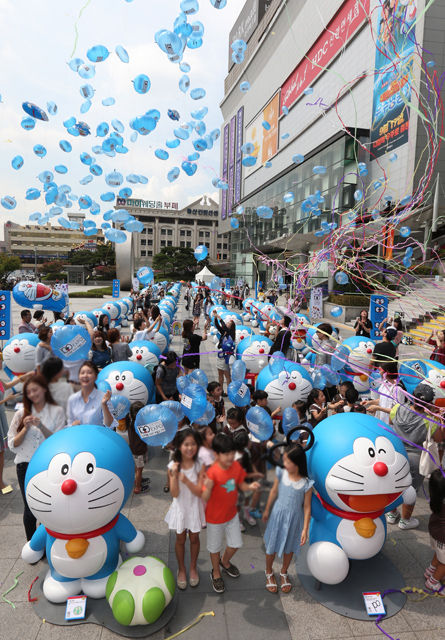 메인이미지  4 : 28일 오전 서울 용산 아이파크몰 야외대광장에서 백화점 개점 9주년을 맞아 열린 '도라에몽 100 비밀 도구전'에서 참석자들이 인형들 사이에 서서 풍선을 하늘로 날리고 있다. (서울=연합뉴스)