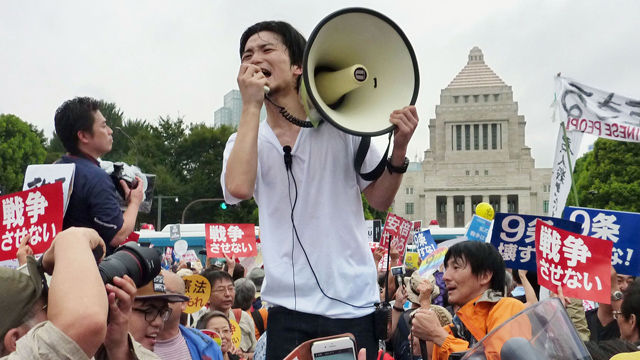 메인이미지  8 : 아베 신조(安倍晋三) 정권이 추진하는 안보법안 반대 시위에서 적극적으로 활동해 주목받은 일본의 학생 단체 '실즈(SEALDs)'의 핵심 멤버인 일본 메이지가쿠인(明治學院)대 4학년 오쿠다 아키(奧田愛基) 씨가 15일 참의원 평화안전법제특별위원회 중앙공청회에 참고인으로 출석해 안보법안에 관한 견해를 밝혔다. 사진은 오쿠다 씨가 2015년 8월 30일 국회 앞에서 확성기를 들고 시위하는 모습. (도쿄 교도=연합)