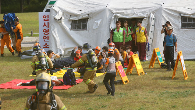 메인이미지  7 : 21일 오후 서울 종로구 경희궁에서 열린 재난대비 긴급구조 종합훈련에서 종로소방서 구조대원들이 부상자들을 임시 응급소로 옮기고 있다.