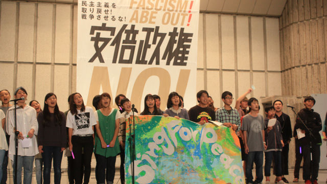 메인이미지  1 : 2일 저녁 일본 도쿄 지요다(千代田)구 소재 히비야(日比谷) 야외음악당에서 3천 객석을 가득 채운 가운데 아베 정권 반대 집회가 열렸다. 참가자들이 소속 단체의 깃발 등을 든채 무대 위에 올라간 모습이다. (도쿄=연합)