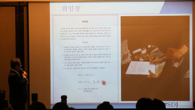 메인이미지  6 : 신동주 전 일본 롯데홀딩스 부회장 내외가 8일 서울 조선호텔에서 기자회견을 열었다. 법률 대리인이 신격호 회장의 위임장을 공개하고 있다. (서울=연합뉴스)