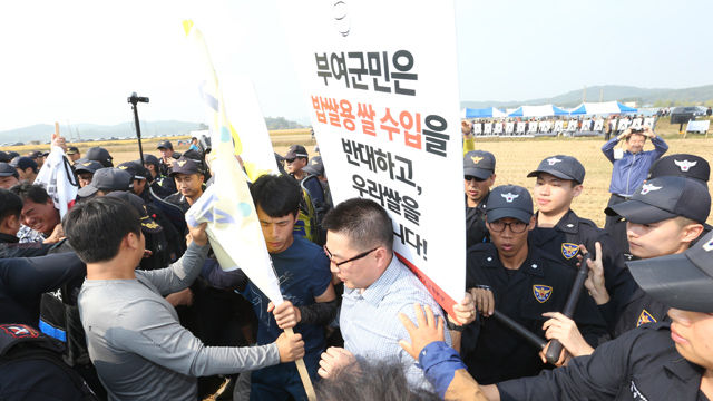 메인이미지  1 : 19일 오후 충남 부여군의 추수가 끝난 논에서 열린 이모작 가을파종 시연회장을 찾은 밥쌀용 쌀 수입반대 우리쌀먹기 운동본부 소속 부여와 서천 농민들이 밥쌀용 쌀 수입 반대 시위를 벌이다 경찰에 의해 행사장 밖으로 밀려나고 있다. 이들은 이날 참석예정이었던 농식품장관에게 항의하기 위해 행사장을 찾았다.