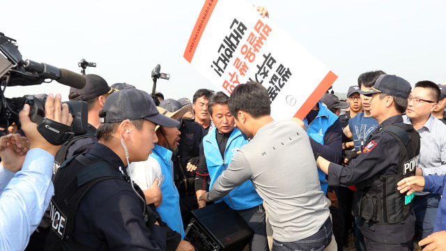 메인이미지  2 :  19일 오후 충남 부여군의 추수가 끝난 논에서 열린 이모작 가을파종 시연회장을 찾은 밥쌀용 쌀 수입반대 우리쌀먹기 운동본부 소속 부여와 서천 농민들이 밥쌀용 쌀 수입 반대 시위를 벌이다 경찰에 의해 행사장 밖으로 밀려나고 있다. 이들은 이날 참석예정이었던 농식품장관에게 항의하기 위해 행사장을 찾았다.