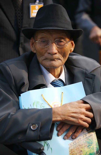 메인이미지  6 : 제20차 이산가족 상봉행사 1회차 둘째날인 21일 오전 금강산호텔에서 열린 개별상봉에 참석하는 북측 정세화(87) 할아버지가 남측에서 온 동생 정순화(86) 할머니에게 줄 선물을 꼭 안고 있다. (금강산=연합뉴스)