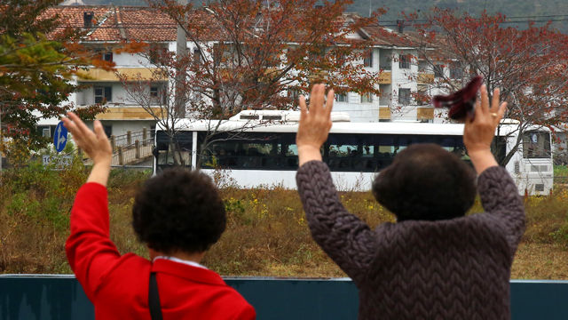 메인이미지  9 :  제20차 이산가족 상봉행사 1회차 마지막날인 22일 오전 금강산 이산가족면회소에서 열린 작별상봉을 마친 남측 가족들이 북측으로 돌아가는 버스를 향해 손을 흔들고 있다.