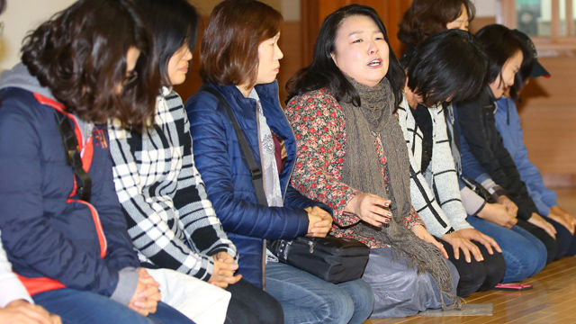 메인이미지  5 : 장애인 가족들이 단상에 올라 무릎을 꿇고 공청회 시작과 시설물 건립을 호소하고 있다.