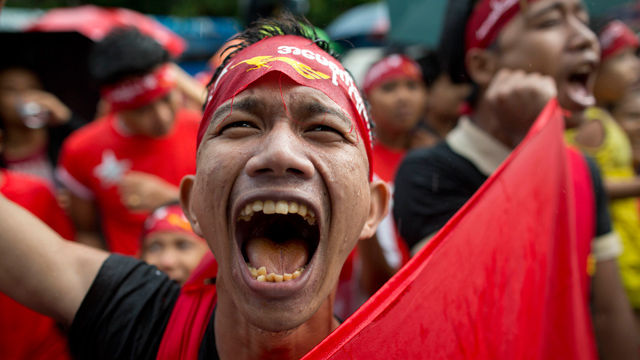 메인이미지  6 : 미얀마 야당 민주주의민족동맹(NLD)의 한 지지자가 9일(현지시각) 양곤 NLD 본부 밖에서 비를 맞으면서도 기쁨을 감추지 못하고 있다. 미얀마 민주화 운동의 상징 아웅산 수치 여사는 과거 반 세기동안 집권해 온 이번 선거의 패배자 군부정권을 자극하지 말라고 당부했다. (양곤 AP=연합)