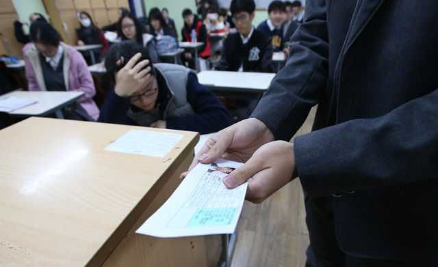 메인이미지  3 : 대학수학능력시험일을 하루 앞둔 11일 오전 서울 서초고등학교에서 수험생들이 선생님으로부터 수험표를 받고 있다.