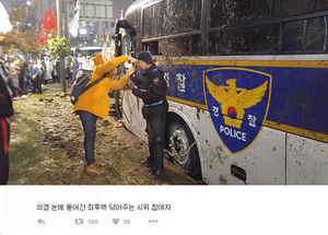시위중 최루액 맞은 의경 눈 씻어주는 시민 사진 화제
