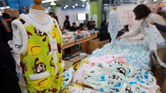 메인이미지  3 : 18일 서울 시민청에서 열린 방한용품 할인 판매 '온맵시 나눔 바자회'에서 한 시민이 유아용 내의 등을 살펴보고 있다.