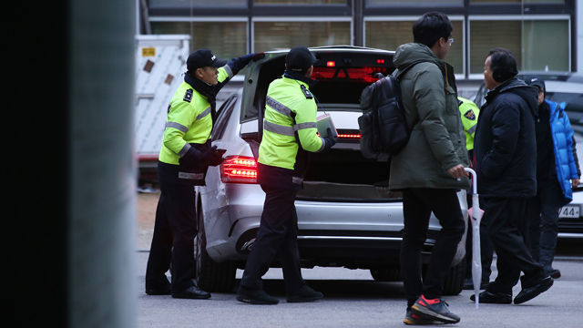 메인이미지  1 : 조계사 신도회 회원들이 30일 오후 서울 조계사에 피신해 있는 한상균 민주노총 위원장을 데리고 나오겠다며 조계사 관음전으로 들어간 가운데 출입구를 지키는 경찰들이 조계사를 나서는 차 트렁크를 검색하고 있다. 