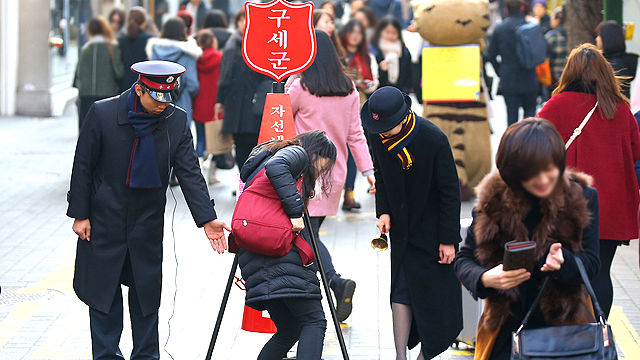 메인이미지  5 : 구세군 자선냄비 모금이 시작된 1일 오후 서울 중구 명동거리에서 시민이 자선냄비에 기부를 하고 있다.