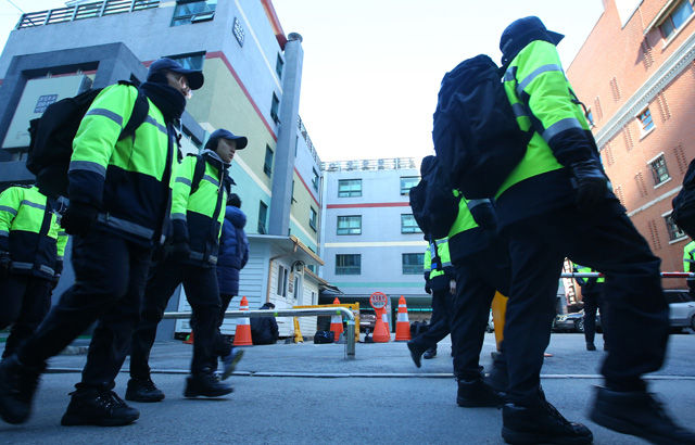 메인이미지  7 : 2차 민중총궐기가 열리는 5일 오후 한상균 민주노총위원장이 있는 서울 종로구 조계사 관음전 앞으로 경찰관들이 근무 교대를 위해 지나고 있다.