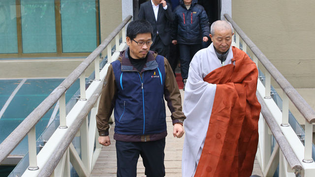 메인이미지  18 : 조계사에 25일째 은신 중이던 한상균 민주노총 위원장이 10일 오전 경찰에 자진출석하기에 앞서 조계사 화쟁위 도법스님과 함께 조계사 관음전을 나서고 있다. (서울=연합뉴스)