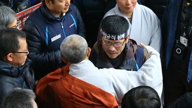 메인이미지  8 : 조계사에 25일째 은신 중이던 한상균 민주노총 위원장이 10일 오전 경찰에 자진출석하기에 앞서 조계사 일주문 앞에서 화쟁위 도법스님과 포옹을 하며 인사를 하고 있다. (서울=연합뉴스)