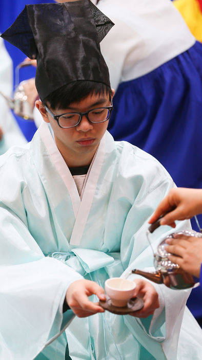 메인이미지  3 : 15일 서울 강북구 수유동 강북구청에서 만 19세를 맞은 고3수험생들을 대상으로 '전통 성년례 시연과 현대 성년례'가 열려 참가 학생이 술을 받고 있다. (서울=연합)