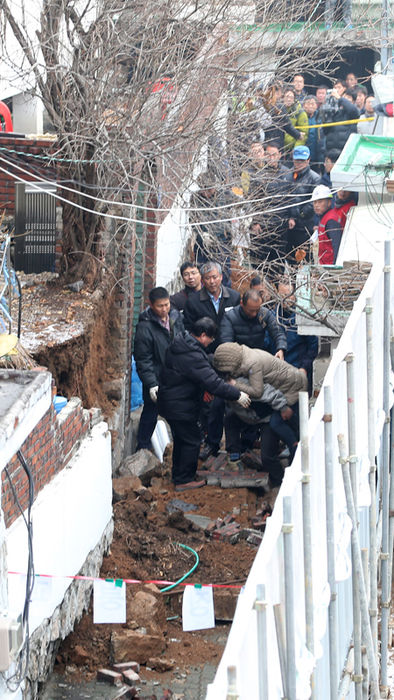 메인이미지  10 : 26일 오전 서울 은평구 녹번동의 한 다세대주택 건설공사 현장 주변 건물 8채에 금이 가 현장을 조사 중이던 은평구청 건축계 관계자가 무너진 담에 다쳐 실려가고 있다.