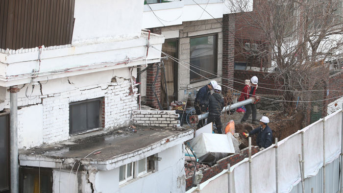 메인이미지  7 : 26일 오전 서울 은평구 녹번동의 한 다세대주택 건설공사 현장 주변 건물 8채에 금이 가 2차 붕괴사고를 막기 위한 지지대 설치작업이 이뤄지고 있다.
