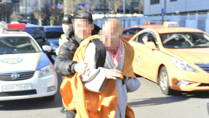 메인이미지  1 : 스님 복장을 한 서모(63)씨가 8일 오전 11시35분께 서울 종로구 정부서울청사를 향해 화염병을 던지려다 제지된 이후 경찰에 연행되고 있다. 