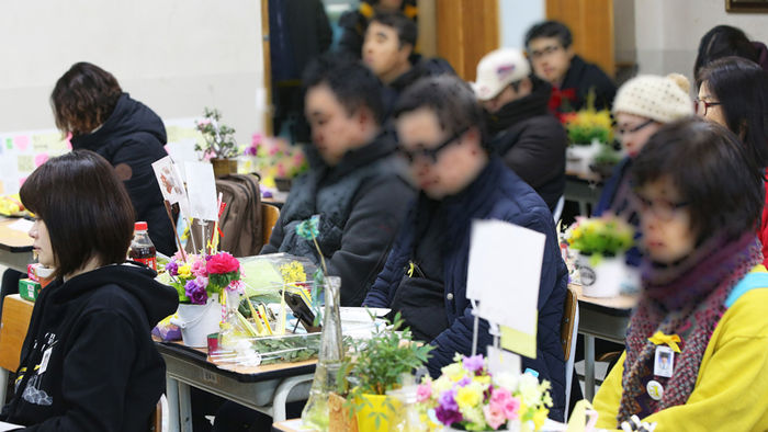 메인이미지  2 : 10일 오후 경기도 안산시 단원고등학교에서 열린 '겨울방학식-기억과 약속의 길'에 참석한 시민들이 희생 학생들을 대신해 명예 3학년 교실 자리에 앉아 있다. '세월호 304 잊지 않을게'와 '리멤버0416'이 시민들과 함께한 이번 행사는 졸업식이 아닌 방학식을 함으로써 미수습자를 계속 기다리겠다는 의미를 담아 진행됐다.