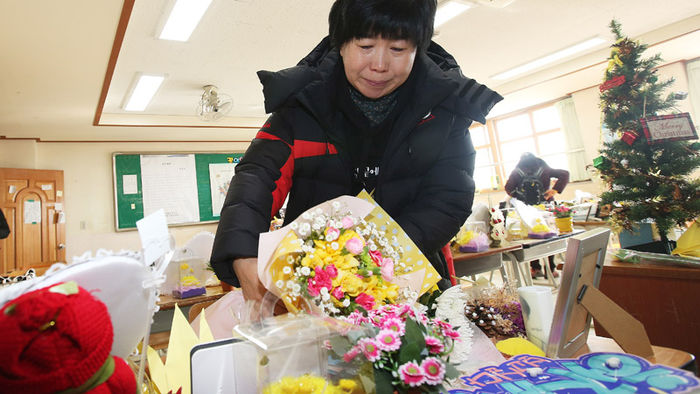 메인이미지  6 : 세월호 참사 생존학생 등 86명의 졸업식이 열린 12일 오전 경기도 안산시 단원고등학교에서 한 유가족이 명예 3학년 교실을 찾아 아들 책상에 꽃다발을 놓고 있다. 