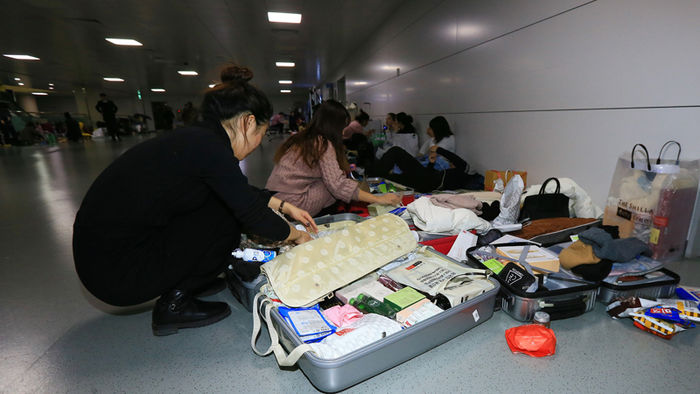 메인이미지  3 : 한파와 강풍으로 제주공항에 결항사태가 빚어진 23일 오후 공항을 빠져나가지 못한 체류객들이 여객터미널에서 잠을 자려고 짐을 풀고 있다.