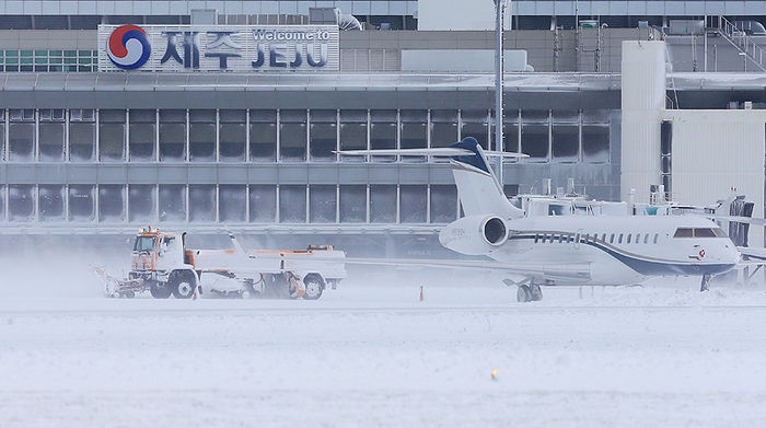 메인이미지  6 : 최강 한파로 제주공항에서 항공기 운항이 잠정 중단된 24일 오전 제설차량이 활주로에 쌓인 눈을 치우고 있다.