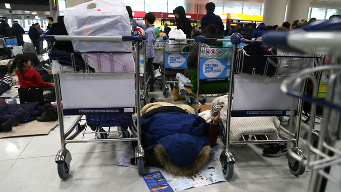 메인이미지  4 : 24일 제주공항이 한파&middot;대설&middot;강풍특보로 항공기 운항이 잠정 중단되자 공항에 남은 체류객들이 여객터미널에서 모포를 덮어 지친 몸을 쉬고 있다.