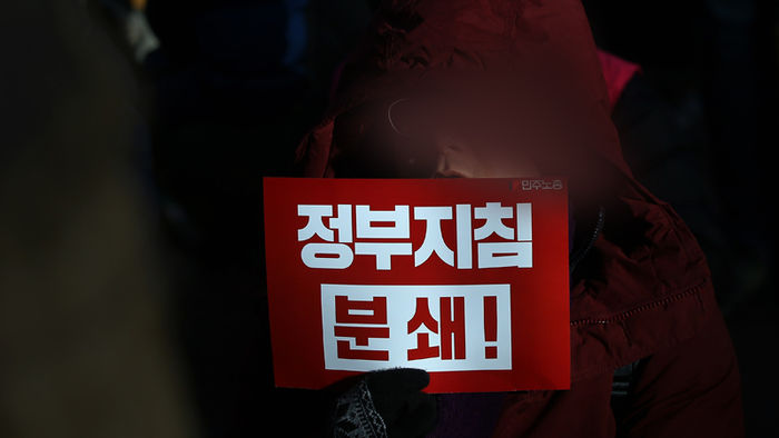 메인이미지  1 : 25일 오후 서울 중구 서울고용노동청 앞에서 열린 민주노총 총파업 선포 결의대회에서 참가자가 피켓을 들고 구호를 외치고 있다.    (서울=연합뉴스)