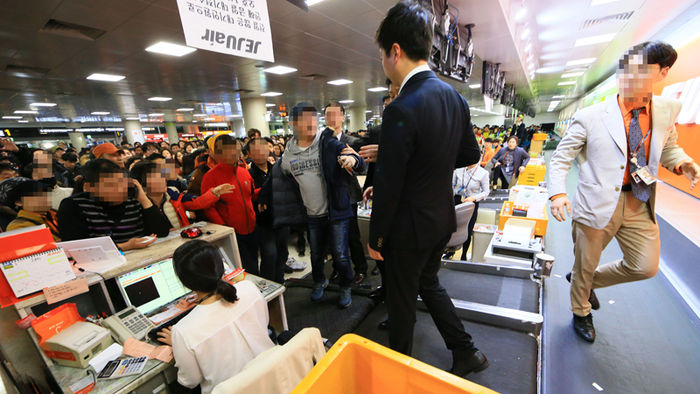 메인이미지  3 : 항공기 운항이 재개된 25일 오후 제주공항 국내선 출발층 수속장에서 기다리다 지친 승객들이 항공사 직원들에게 강하게 항의하고 있다.