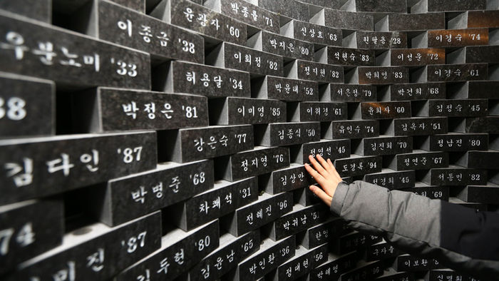메인이미지  3 : 대구지하철 참사 13주기를 하루 앞둔 17일 오후 대구 중앙로역 지하 2층 '기억의 공간'을 찾은 학생들이 고인의 이름이 새겨진 추모벽을 만지고 있다. 