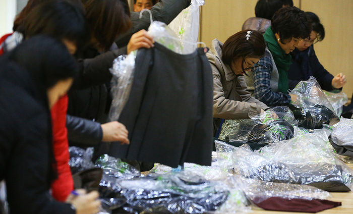 메인이미지  8 : 20일 오전 서울 동대문구청에서 열린 교복 나눔장터 행사를 찾은 주민들이 교복을 살펴보고 있다. 이번 행사에는 관내 6개 중학교와 4개 고등학교 등 총 10곳이 참여했다. 행사장을 찾은 주민들은 품목 관계 없이 장당 2천원에 5장까지 옷을 구매할 수 있다. 
