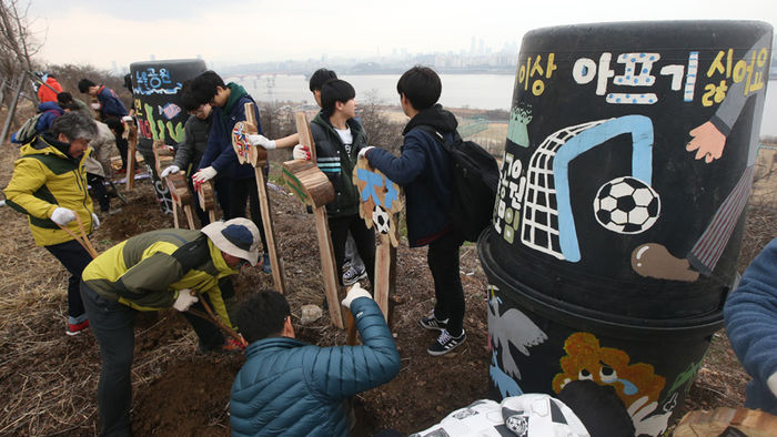 메인이미지  4 : 5일 오전 서울 마포구 상암동 노을공원에서 열린 '천인공NO쌩큐 축구장 건설, 1천명 나무심기' 행사에 참가한 노을공원시민모임 회원과 시민들이 마포구가 공원에 추진 중인 축구장, 풋살구장 등 체육시설 건립사업에 반대하는 나무팻말을 세우고 있다.